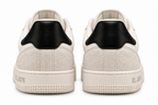 A pair of low-top sneakers shown from the back, featuring off-white suede and leather uppers with a contrasting black heel tab, and textured off-white soles with 'EL JEFE' branding.