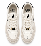 A pair of low-top sneakers shown from a top-down view on a white background. The shoes are primarily off-white and beige suede and leather, featuring black accents on the collar, tongue, and side, a gold-toned metal detail on the laces, and the brand name 'EL JEFE ENERGY' printed on the tongue.