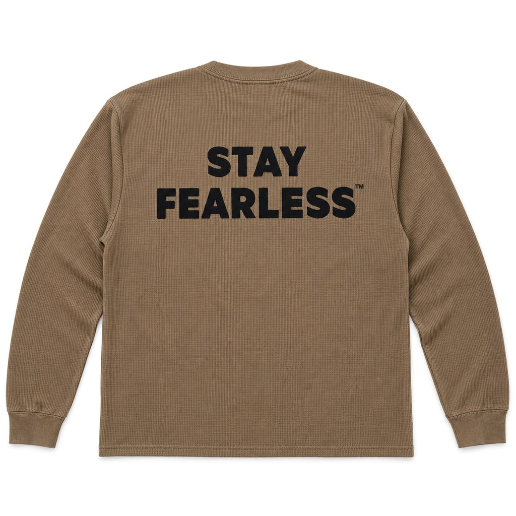 A brown long-sleeve waffle-knit t-shirt shown from the back, featuring the words 'STAY FEARLESS' printed in bold black capital letters across the upper back.