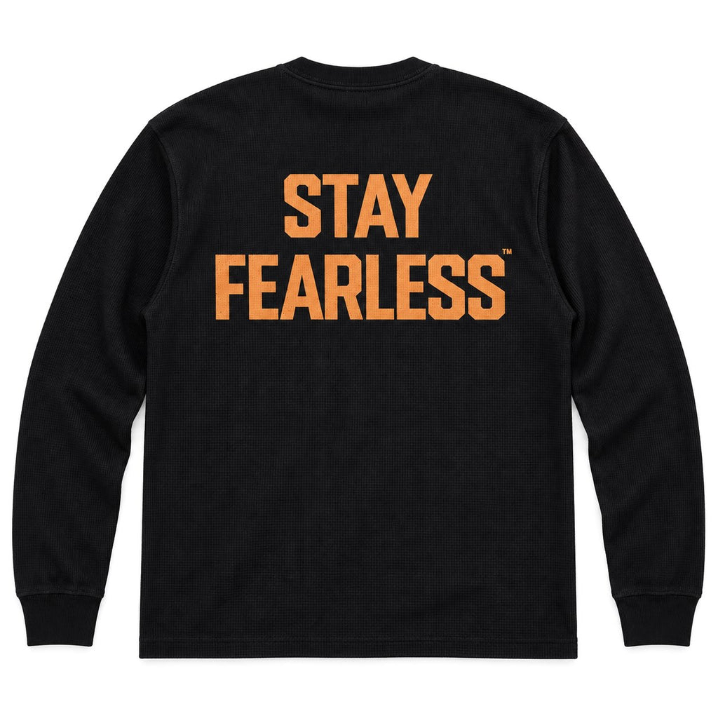 A black long-sleeve crewneck sweatshirt shown from the back, featuring the words 'STAY FEARLESS' printed in a distressed orange font across the upper back.