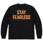 A black long-sleeve crewneck sweatshirt shown from the back, featuring the words 'STAY FEARLESS' printed in a distressed orange font across the upper back.