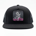 Black trucker cap with a skull and roses design on a white background