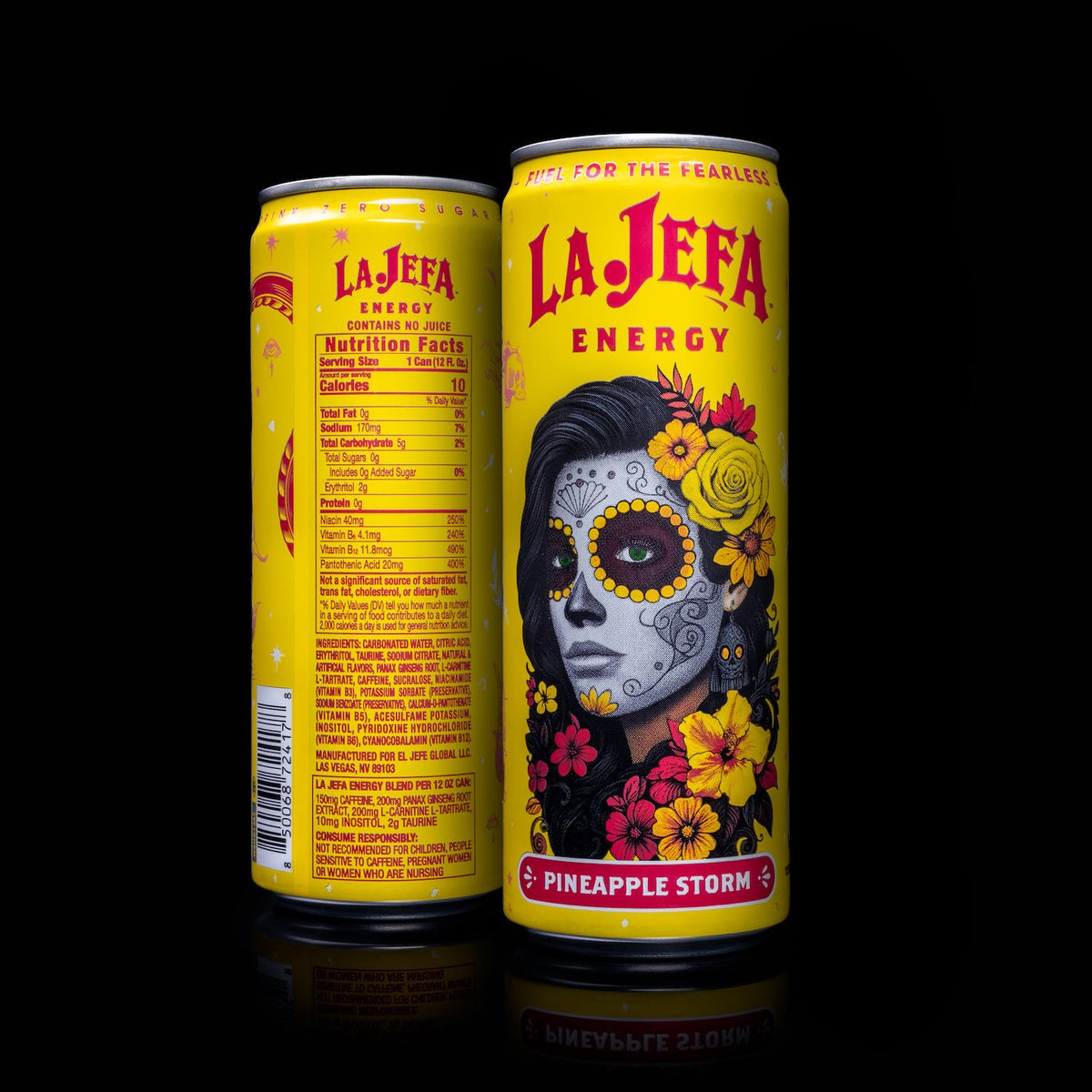 Two La Jefa Energy beverage cans in the Pineapple Storm flavor, shown front and back on a black reflective background. The can features a bright yellow design with a Day of the Dead style woman's face, red and yellow flowers, and the La Jefa Energy branding.