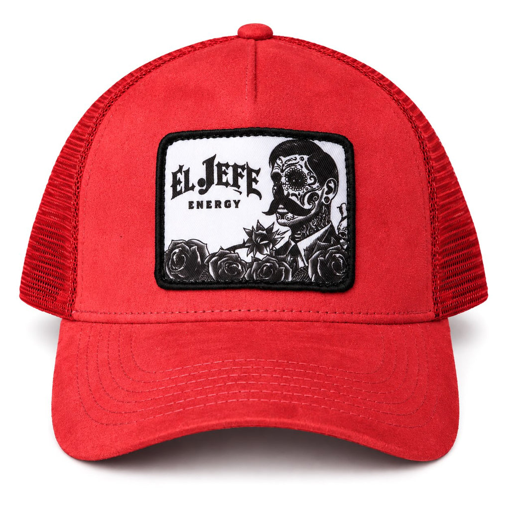 A red suede trucker hat with a rectangular embroidered patch on the front. The patch has a white background with a black graphic of a skull wearing a mustache and roses, and the text 'EL JEFE ENERGY'.