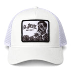 A white suede trucker hat with white mesh side panels and a black rectangular patch on the front featuring the text 'EL JEFE ENERGY' and a black-and-white skull illustration with roses.
